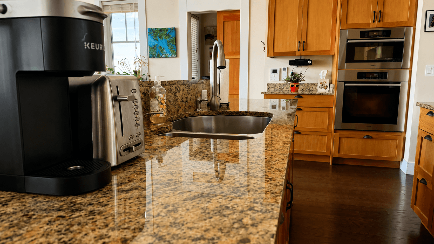 A kitchen sink and stone counters after cleaning